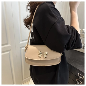 Sac sous le bras beige avec boucle dorée en forme de nœud en vue latérale