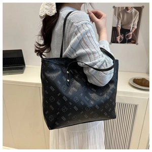 Détail d'un grand sac cabas noir avec texture grainée et rivets dorés de renforcement