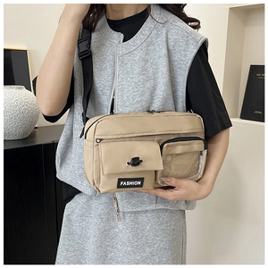 Close-up of beige crossbody bag showing multi-pocket design and transparent PVC pocket