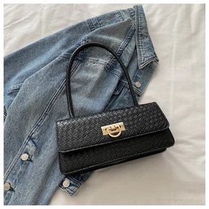 Detail of black crocodile texture leather and gold metal buckle on a shoulder bag