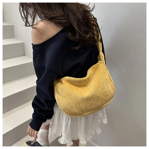 Detail view of yellow corduroy crescent bag showing soft textured fabric and casual style