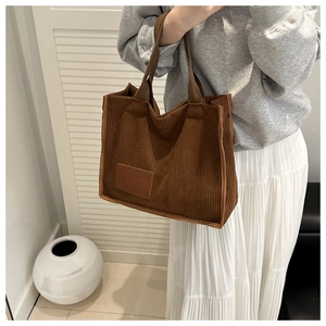 Braune Cord-Einkaufstasche in Lifestyle-Szene mit minimalistischem Outfit gezeigt