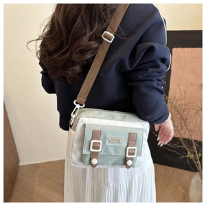 Detailopname van mintgroene nylon crossbodytas met verstelbare bruine schouderriem