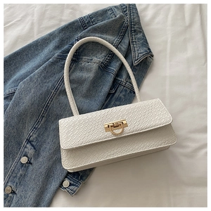 Detail of white crocodile pattern baguette bag with elegant golden D-buckle closure
