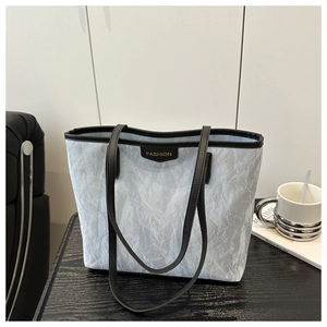 Detail of vintage tote bag with marble texture finish, black straps and Fashion logo