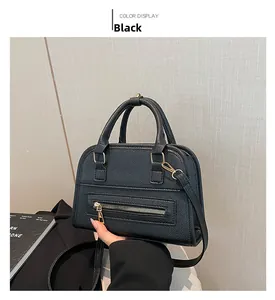 Close-up of black litchi pattern leather tote with gold hardware and zipper details