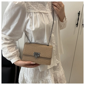 Detail of khaki stone pattern crossbody bag with gunmetal chain strap and lock