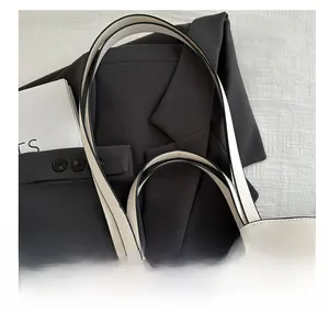 Close-up of cream leather tote strap with black edge paint and fine stitching details