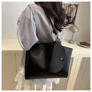 Detail of minimalist black tote bag with matching detachable coin purse and smooth texture