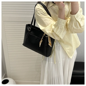 Dettaglio borsa shopper nera con cuciture bianche a contrasto ed elegante foulard di seta stampato