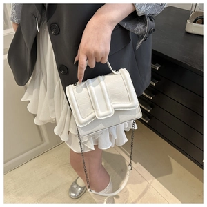 Vue détaillée du sac à main blanc motif crocodile avec chaîne en métal et poignée