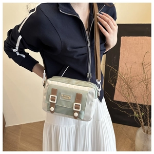 Fashion Lovely canvas crossbodytas in beige en groen gedragen door een model in een kamer
