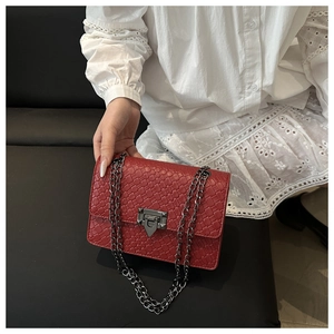 Detail of red woven leather texture and silver chain strap on a stylish handbag