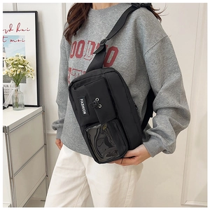 Detail of black utility sling bag with transparent PVC window and fashion woven label