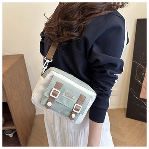 Detailopname van mintgroene nylon crossbodytas met schattige konijnenpatch en geweven riem