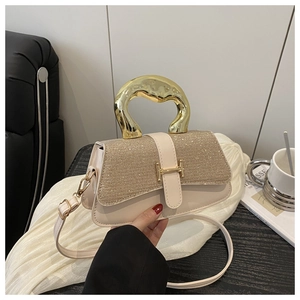 Detail of glitter flap and golden H-clasp on cream shoulder bag with metal handle