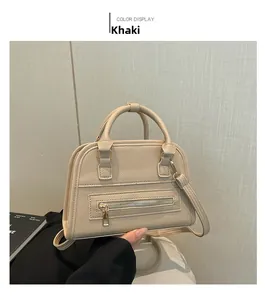 Detail showing khaki lychee grain leather Boston bag with elegant golden hardware