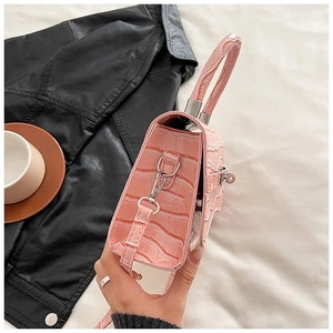 Detail of pink croc-embossed PU leather handbag with silver hooks and thin shoulder strap