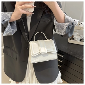 Détail du sac bandoulière blanc à motif crocodile avec chaîne en métal et poignée