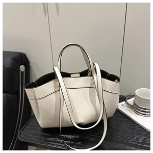 Close-up of minimalist off-white tote bag with black edge paint and dual straps