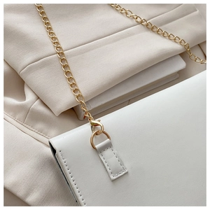 Detail of white chain shoulder bag with smooth faux leather and gold metal hardware