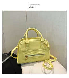 Detail view of the yellow lychee grain leather Boston bag with golden zipper and strap