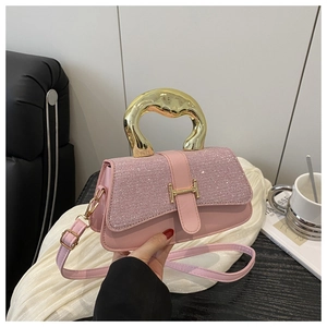 Detail of pink PU leather handbag showing golden sculptural metal handle and H buckle clasp