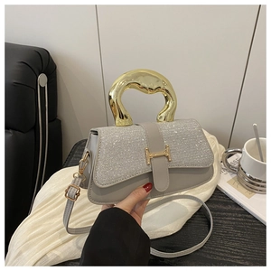 Detail of grey leather crossbody bag with silver sequins and unique gold metal handle