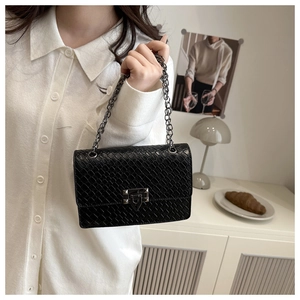 Close-up of black stone pattern crossbody bag with silver chain and metal twist lock