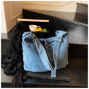 Retro blue denim tote bag displayed on black stairs with elegant lifestyle props