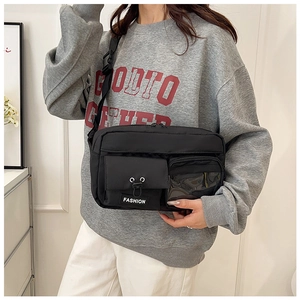 Detail of durable black nylon crossbody bag with drawstrings and clear PVC pocket