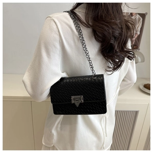 Close-up of woven texture and silver-tone triangle lock on black shoulder bag