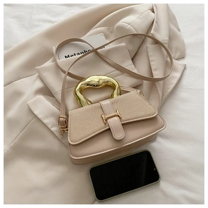 Close-up of beige textured fabric handbag with gold irregular metal handle and H buckle