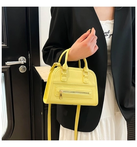 Detail of yellow pebble leather tote with quilted texture and gold zipper accents