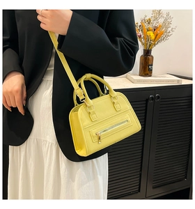 Detail of yellow lychee leather Boston bag with metal zipper and adjustable strap