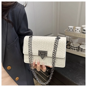 Detail of white woven textured crossbody bag featuring vintage gunmetal chain and square lock