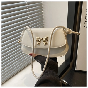 Détail du sac bandoulière en cuir PU blanc avec nœud doré et bandoulière corde