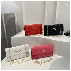 Multiple colors of bow-knot chain bags displayed on white minimalist steps