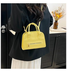 Detail of yellow lychee pattern Boston bag showing smooth leather texture and golden zippers
