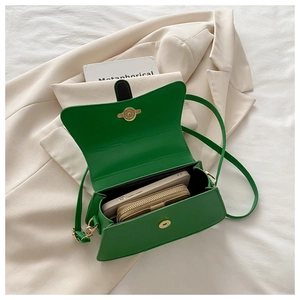 Interior view of emerald green leather flap bag showing storage space for phone and wallet