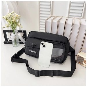 Détail d'un sac bandoulière en nylon noir avec poche transparente et sangle