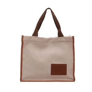 Minimalist beige corduroy tote bag with brown trim and fashion leather tag detail