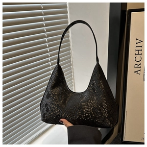 Close-up detail showing the black snake skin pattern and texture on a leather shoulder bag