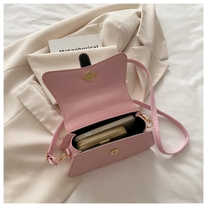 Interior detail of pink leather crossbody bag showing storage for phone and wallet