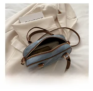 Detail view of denim handbag interior showing storage capacity for phone and wallet