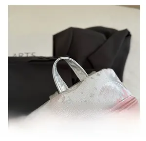Detailed close-up of pink floral prints and sturdy handle on silver fashion backpack
