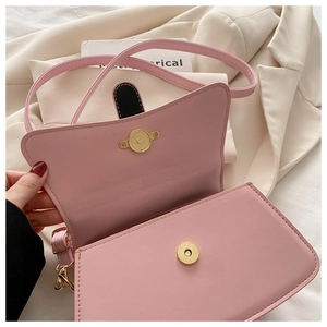 Detail of pink geometric crossbody bag with magnetic flip cover on cream background