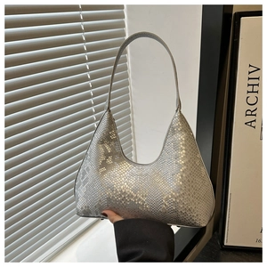 Detail view of silver snake-pattern hobo bag with metallic finish and bottom rivets