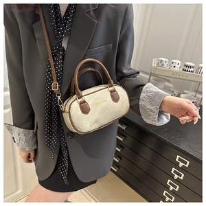 Détail du sac Boston rétro en toile crème avec poignées en cuir marron et boucle en métal doré