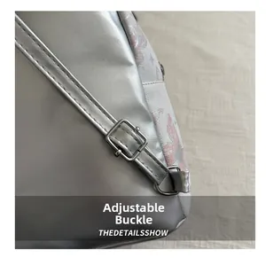 Detailed close-up of the adjustable metal buckle and stitching on a silver PU backpack